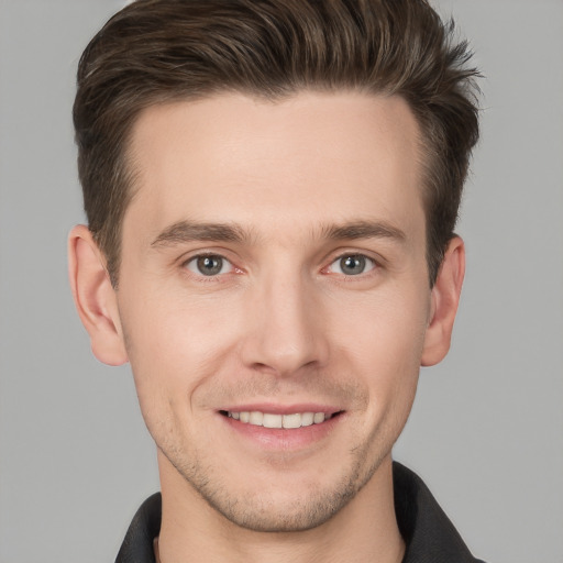 Joyful white young-adult male with short  brown hair and grey eyes