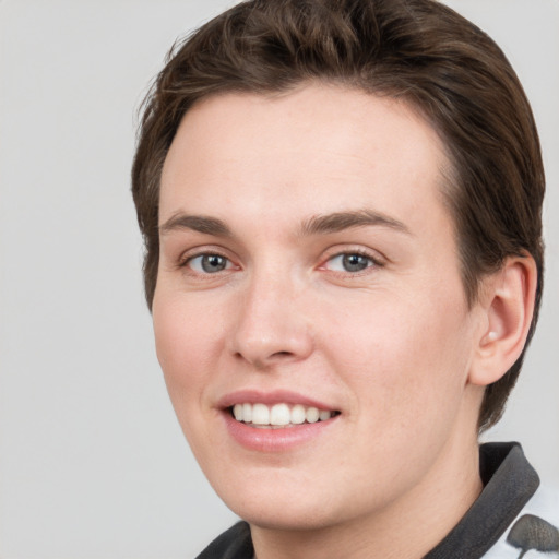 Joyful white young-adult female with short  brown hair and grey eyes