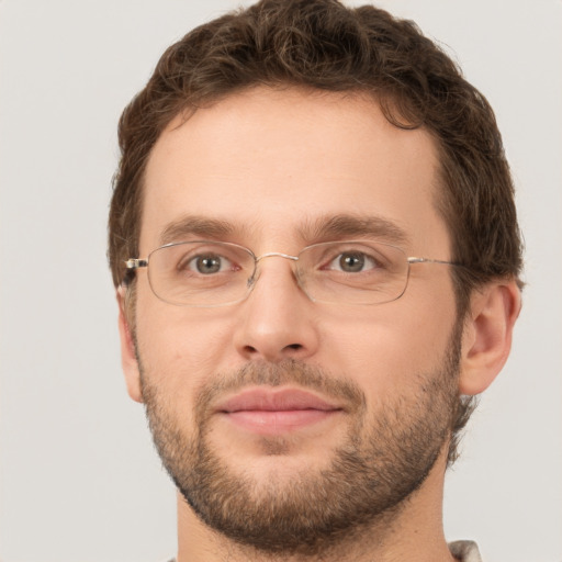 Joyful white young-adult male with short  brown hair and green eyes