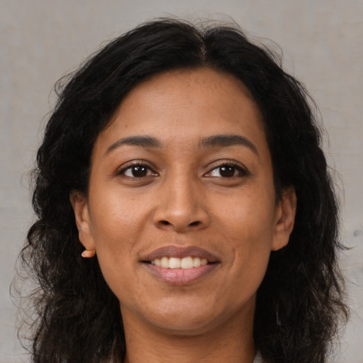 Joyful latino adult female with long  brown hair and brown eyes