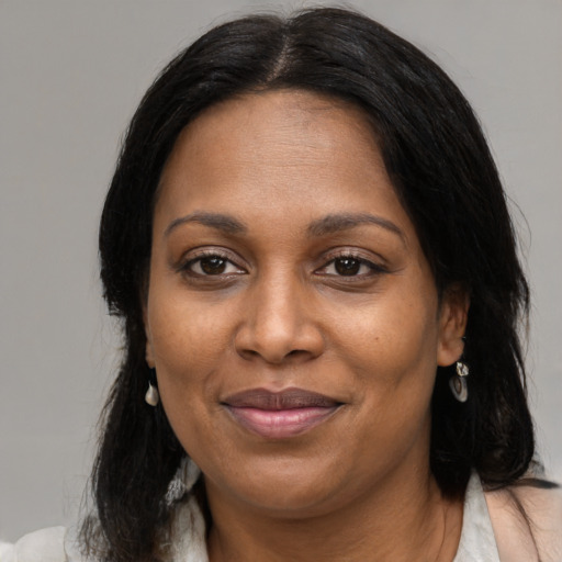 Joyful black adult female with medium  brown hair and brown eyes