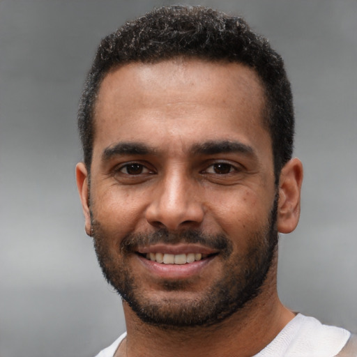 Joyful black young-adult male with short  black hair and brown eyes