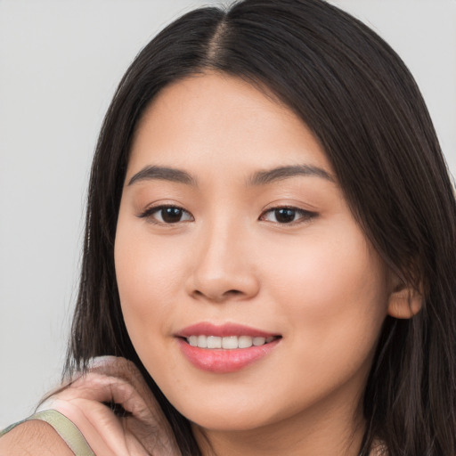 Joyful white young-adult female with long  brown hair and brown eyes