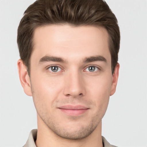 Joyful white young-adult male with short  brown hair and grey eyes