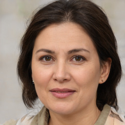 Joyful white adult female with medium  brown hair and brown eyes