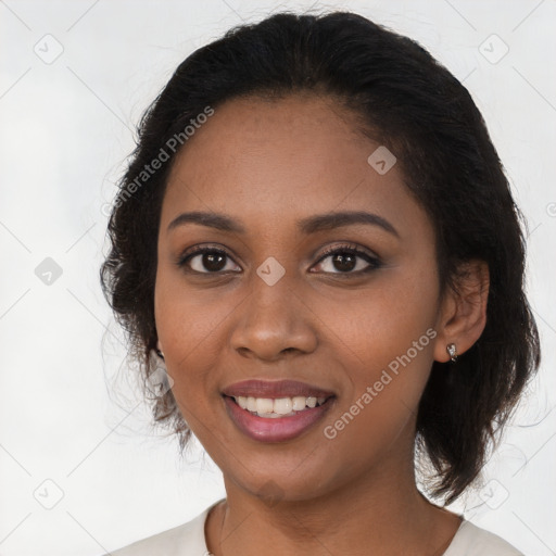 Joyful black young-adult female with long  brown hair and brown eyes