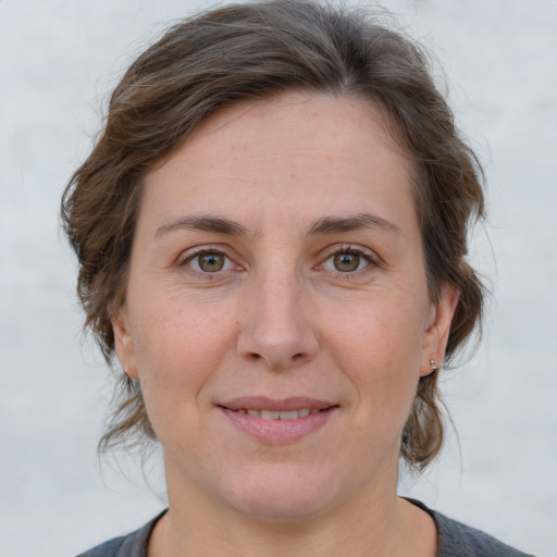 Joyful white adult female with medium  brown hair and grey eyes