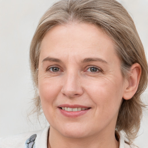 Joyful white adult female with medium  brown hair and blue eyes