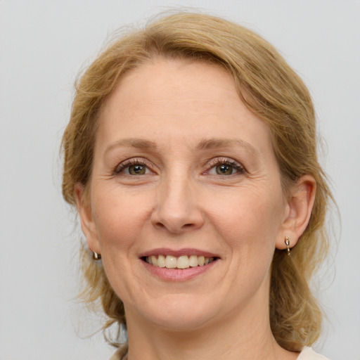 Joyful white adult female with medium  brown hair and green eyes