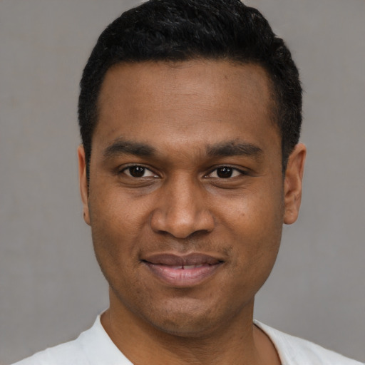 Joyful latino young-adult male with short  black hair and brown eyes