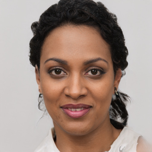 Joyful black young-adult female with short  black hair and brown eyes