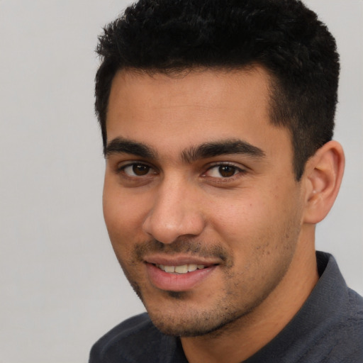 Joyful white young-adult male with short  black hair and brown eyes