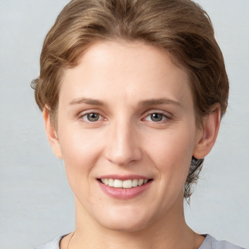 Joyful white young-adult female with short  brown hair and grey eyes