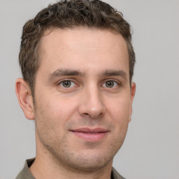 Joyful white young-adult male with short  brown hair and grey eyes