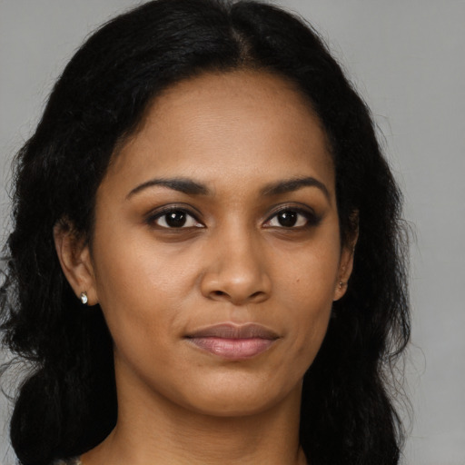 Joyful black young-adult female with long  brown hair and brown eyes