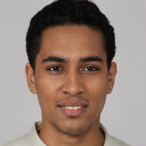 Joyful latino young-adult male with short  black hair and brown eyes
