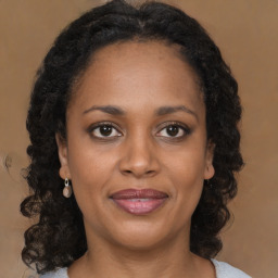 Joyful black adult female with medium  brown hair and brown eyes