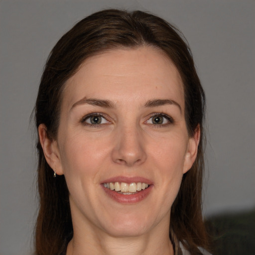 Joyful white young-adult female with long  brown hair and grey eyes