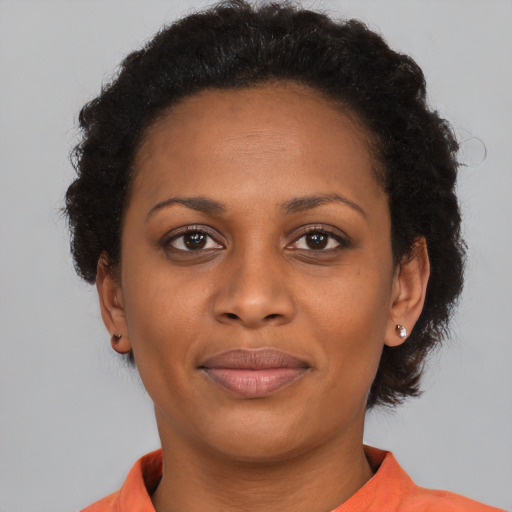 Joyful black adult female with short  brown hair and brown eyes