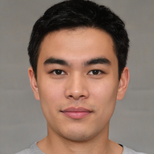 Joyful asian young-adult male with short  black hair and brown eyes