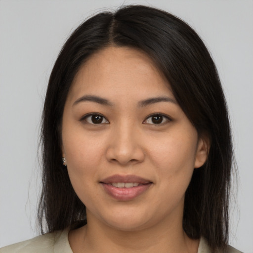 Joyful latino young-adult female with long  brown hair and brown eyes