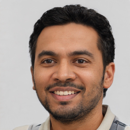 Joyful latino young-adult male with short  black hair and brown eyes