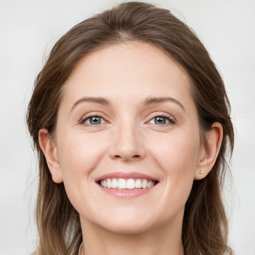 Joyful white young-adult female with long  brown hair and grey eyes