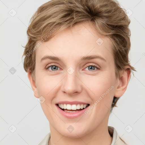 Joyful white young-adult female with short  brown hair and grey eyes