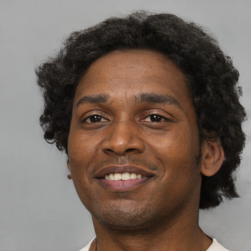 Joyful black adult male with short  brown hair and brown eyes