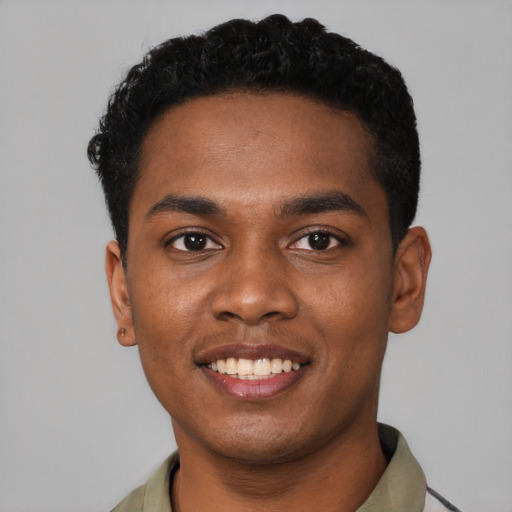 Joyful black young-adult male with short  black hair and brown eyes