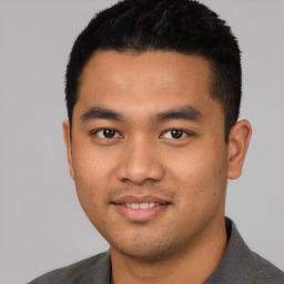 Joyful latino young-adult male with short  black hair and brown eyes