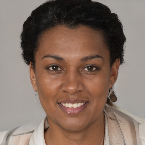 Joyful black young-adult female with short  brown hair and brown eyes