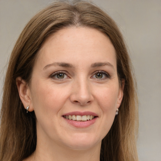 Joyful white young-adult female with long  brown hair and green eyes