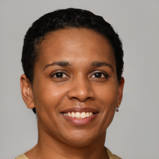 Joyful black young-adult female with short  black hair and brown eyes