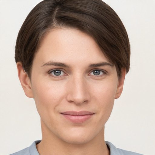 Joyful white young-adult female with short  brown hair and grey eyes