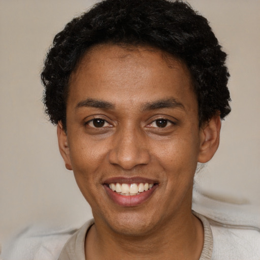 Joyful black young-adult male with short  black hair and brown eyes