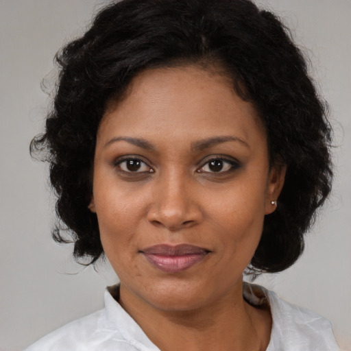 Joyful black young-adult female with medium  brown hair and brown eyes