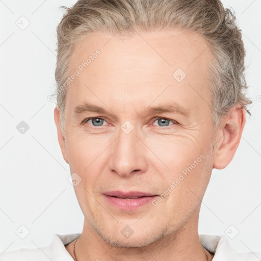 Joyful white adult male with short  brown hair and grey eyes