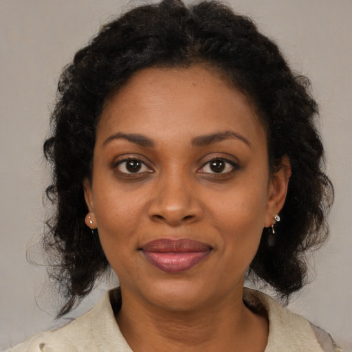Joyful black young-adult female with medium  brown hair and brown eyes