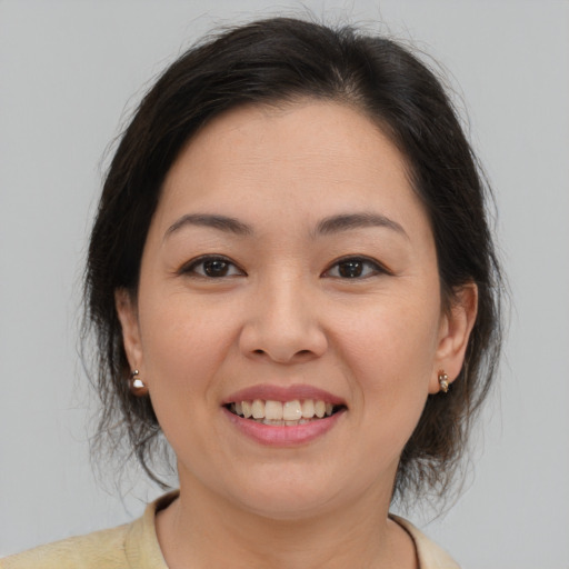 Joyful asian young-adult female with medium  brown hair and brown eyes