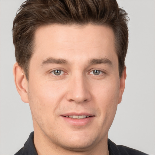 Joyful white young-adult male with short  brown hair and grey eyes