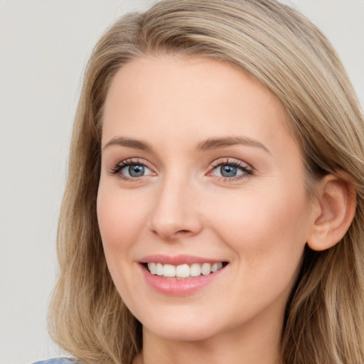 Joyful white young-adult female with long  brown hair and blue eyes