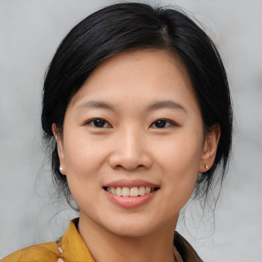 Joyful asian young-adult female with medium  black hair and brown eyes