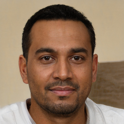 Joyful black adult male with short  brown hair and brown eyes