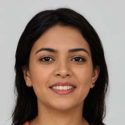 Joyful latino young-adult female with long  brown hair and brown eyes