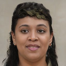 Joyful black young-adult female with long  brown hair and brown eyes