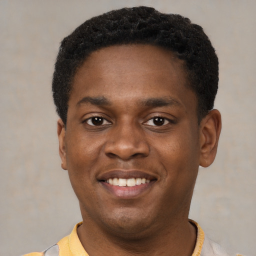 Joyful black young-adult male with short  black hair and brown eyes
