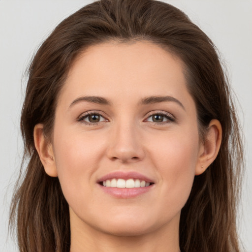 Joyful white young-adult female with long  brown hair and brown eyes