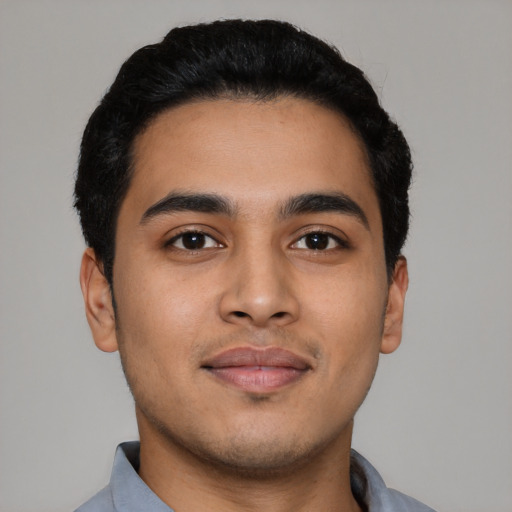 Joyful latino young-adult male with short  black hair and brown eyes