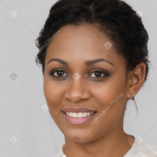 Joyful black young-adult female with long  black hair and brown eyes